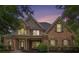 Charming two-story brick home with a welcoming front porch as the sun sets in the evening at 448 Cape Ivey Dr, Dacula, GA 30019