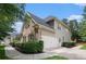 A lovely two-story home's side shows a spacious two-car garage and lush landscaping at 448 Cape Ivey Dr, Dacula, GA 30019