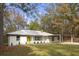 Charming single-story home features a yellow door and attached carport, nestled among mature trees at 2013 Ridge Rd, Dallas, GA 30157