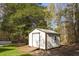 Well-maintained storage shed with ramp in backyard with mature trees and some lawn at 2013 Ridge Rd, Dallas, GA 30157