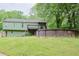 Backyard view of a home, a green lawn, a wooden deck, and a round swimming pool at 3785 Willow Ridge Rd, Douglasville, GA 30135