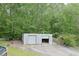 Exterior view of a spacious metal outbuilding with concrete parking area and a sloped lawn at 3785 Willow Ridge Rd, Douglasville, GA 30135