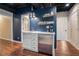 Finished basement with stylish wet bar with white cabinets, stainless steel refrigerator, and wood flooring at 751 Yorkshire Sw Pl, Lilburn, GA 30047