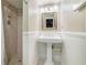 Updated bathroom with pedestal sink, tiled shower, wainscoting, and decorative mirror and lighting at 751 Yorkshire Sw Pl, Lilburn, GA 30047