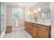 Elegant bathroom featuring dual sinks, wood cabinets, marble countertops, and a separate shower at 751 Yorkshire Sw Pl, Lilburn, GA 30047