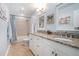 Well-lit bathroom with double sinks, granite countertops, tile floors, and updated fixtures at 751 Yorkshire Sw Pl, Lilburn, GA 30047