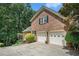 Brick home showcases a two-car garage with white doors and a well-maintained driveway surrounded by greenery at 751 Yorkshire Sw Pl, Lilburn, GA 30047