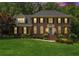 Traditional brick home with a manicured lawn, symmetrical windows, and mature landscaping at 751 Yorkshire Sw Pl, Lilburn, GA 30047