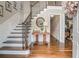 Inviting foyer with wood staircase, decorative trim, hardwood floors and stylish table at 751 Yorkshire Sw Pl, Lilburn, GA 30047