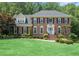 Charming two-story brick home featuring a well-manicured lawn and inviting blue front door at 751 Yorkshire Sw Pl, Lilburn, GA 30047