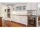 Kitchen area with stainless steel wine cooler, white cabinets, and hardwood floors at 751 Yorkshire Sw Pl, Lilburn, GA 30047