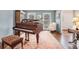 Elegant living room featuring a grand piano, plush seating, and natural light from the windows at 751 Yorkshire Sw Pl, Lilburn, GA 30047