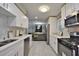 Modern kitchen featuring sleek white cabinets, stainless steel appliances, and tiled floors at 1626 Oak Knoll Se Cir, Atlanta, GA 30315