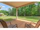 Covered back porch overlooking a spacious lawn and wooded area at 305 Spooner Dr, Mcdonough, GA 30252