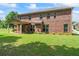 Brick home's backyard featuring a covered patio and expansive lawn at 305 Spooner Dr, Mcdonough, GA 30252