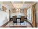 Formal dining room featuring coffered ceilings, elegant chandelier, and stylish furnishings for a sophisticated feel at 305 Spooner Dr, Mcdonough, GA 30252