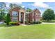 Beautiful brick home with a well-manicured lawn and colorful landscaping, creating a welcoming curb appeal at 305 Spooner Dr, Mcdonough, GA 30252