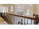 Upstairs hallway with dark railing and banisters, with views to downstairs and outside at 305 Spooner Dr, Mcdonough, GA 30252