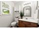 Charming powder room offers a decorative mirror, plants and a window for natural light at 4941 Meadow Lane, Marietta, GA 30068