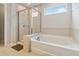 Bright bathroom featuring soaking tub, tile surround, glass shower and natural light at 340 Paulownia Cir, Mcdonough, GA 30253