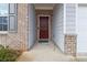 Inviting front entrance featuring a brick surround, a maroon front door, and gray siding at 340 Paulownia Cir, Mcdonough, GA 30253