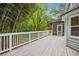 Wide white deck showcasing a screened-in porch overlooking bamboo and various trees in a tranquil outdoor setting at 3688 Burnley Court, Lithonia, GA 30038