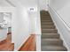 Bright entryway with wood floors, leading to carpeted stairs and a glimpse of the modern kitchen at 3688 Burnley Court, Lithonia, GA 30038