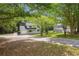 Two-story home with a covered porch, nestled amongst mature trees on a spacious lot with a long driveway at 3688 Burnley Court, Lithonia, GA 30038