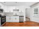 Well-lit kitchen features stainless steel appliances, granite counters, white cabinets, and wood flooring at 3688 Burnley Court, Lithonia, GA 30038