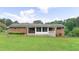 A big backyard view with the home, the screen room, and a green lawn at 4642 Elmhurst Dr, Douglasville, GA 30135