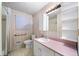 Pink bathroom featuring tile floors and walls, ample cabinet and vanity storage at 4642 Elmhurst Dr, Douglasville, GA 30135