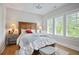 Serene bedroom featuring a wooden headboard, soft bedding, and large windows with plantation shutters at 2578 Middle Coray Cir, Marietta, GA 30066