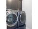 Laundry room showcasing modern, front-loading washer and dryer in a beautiful navy finish at 2578 Middle Coray Cir, Marietta, GA 30066