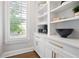 Bright pantry featuring white cabinets, gold hardware, and open shelving by the window at 2578 Middle Coray Cir, Marietta, GA 30066