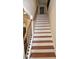 Staircase with white risers, wood treads and a dark metal and wood railing at 4840 Shiloh Springs Rd, Cumming, GA 30040