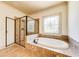 Modern bathroom with a glass-enclosed shower, soaking tub, and a decorative window at 5925 Boulder Bluff Dr, Cumming, GA 30040