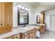 Bright bathroom featuring granite counters with double sinks and dark wood cabinets at 5925 Boulder Bluff Dr, Cumming, GA 30040