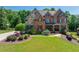 Charming two-story home with brick and stone facade, lush lawn and decorative landscaping at 5925 Boulder Bluff Dr, Cumming, GA 30040