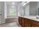 Bathroom featuring double sinks, a soaking tub and modern cabinets at 1912 Riverton Dr, Suwanee, GA 30024
