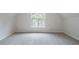 Empty carpeted room featuring a single window and neutral walls, ready for personalization at 1912 Riverton Dr, Suwanee, GA 30024