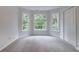 Empty carpeted room with a window bay, offering plenty of natural light and closet space at 1912 Riverton Dr, Suwanee, GA 30024