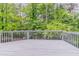 Enjoy the view of the lush greenery from this spacious wooden deck with painted railings at 1912 Riverton Dr, Suwanee, GA 30024