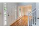 Bright foyer with hardwood floors, white trim and clear sightlines to dining room at 1912 Riverton Dr, Suwanee, GA 30024