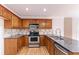 Functional kitchen with stainless steel appliances, dark countertops and wood cabinets at 1912 Riverton Dr, Suwanee, GA 30024