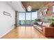 Bright living room featuring hardwood floors, brick accent wall with modern industrial accents and balcony access at 400 W Peachtree Nw St # 3614, Atlanta, GA 30308
