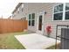 Backyard featuring a concrete patio, small fenced yard, and beige siding at 7621 Avalon Blvd, Fairburn, GA 30213