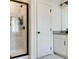 Bathroom featuring shower with glass door, marble tile, and storage shelves at 7621 Avalon Blvd, Fairburn, GA 30213
