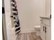 Bathroom with shower/tub combo, striped shower curtain, and white vanity with storage at 7621 Avalon Blvd, Fairburn, GA 30213
