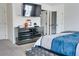 A modern bedroom with a mirrored dresser, a TV, and neutral-toned walls at 7621 Avalon Blvd, Fairburn, GA 30213