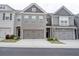 Townhome exterior showcasing the building's facade, garages, and well-maintained landscaping at 7621 Avalon Blvd, Fairburn, GA 30213